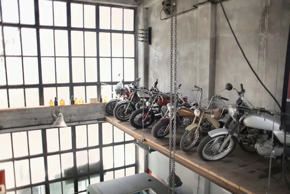Pencereli depoda raflarda sıralı motosikletler