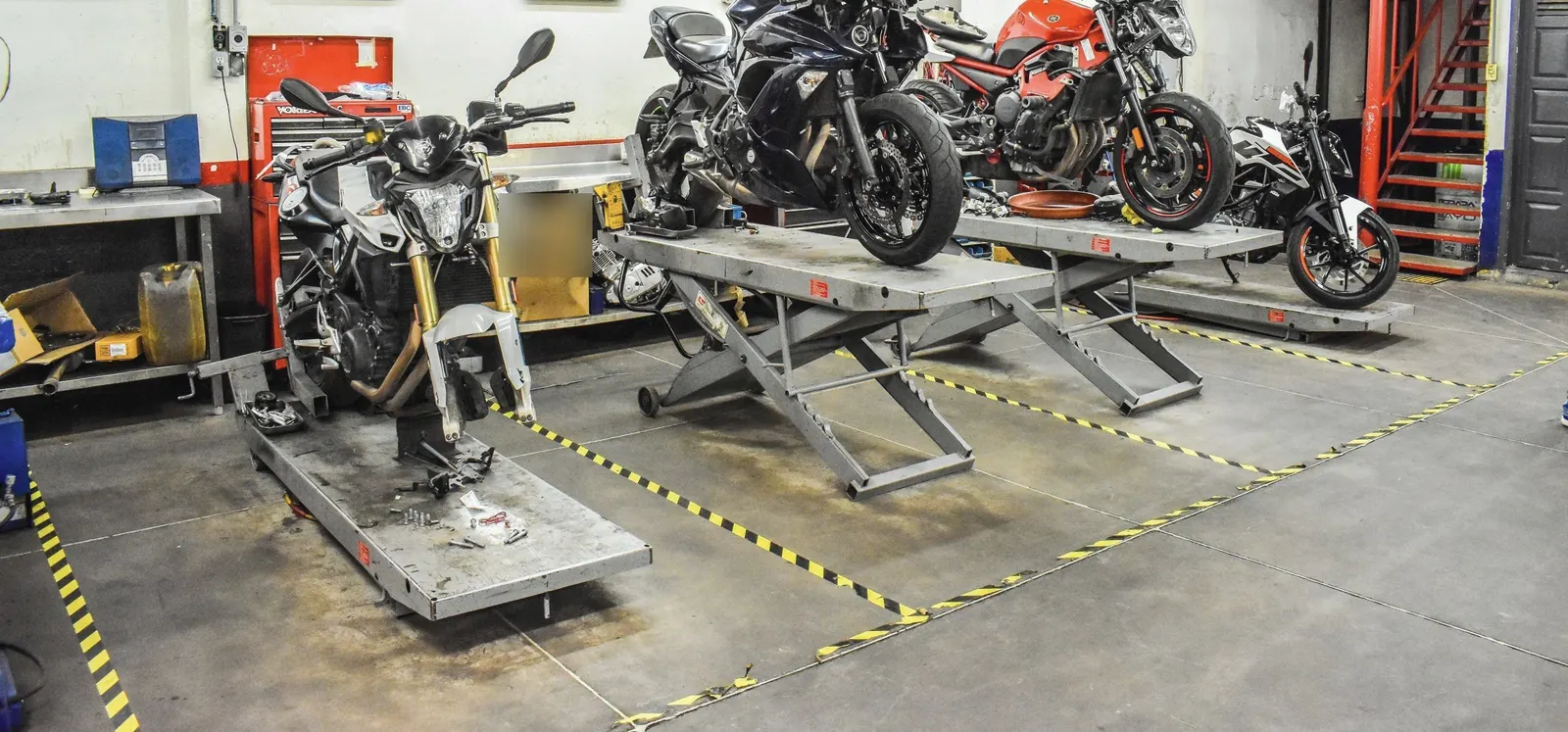 Motosiklet atölyesinde liftler üzerinde servis bekleyen motosikletler